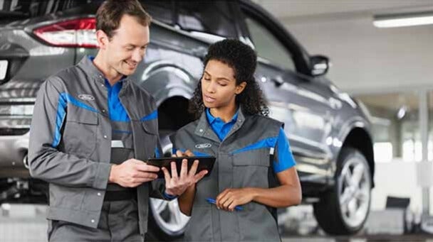 Technician performing diagnostics on a Ford vehicle