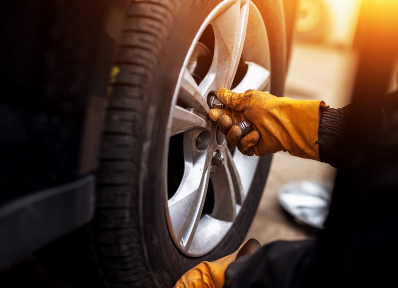 a mechanic performing a tire rotation on a vehicle